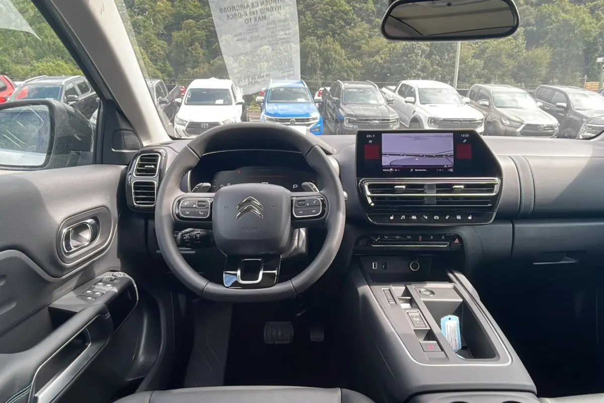 Vue intérieure du poste de conduite du Citroën C5 Aircross Hybrid 2025, avec volant multifonction et écran tactile central.