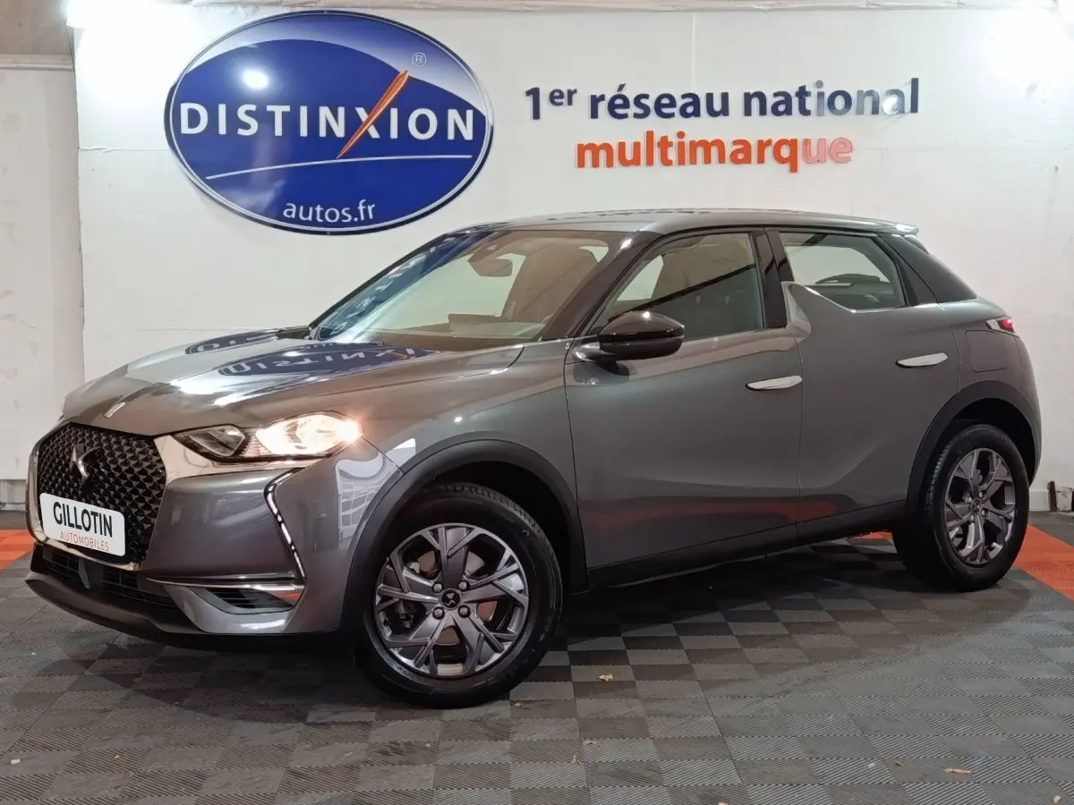 DS3 Crossback gris foncé vu de 3/4 avant droit avec phares allumés et calandre distinctive DS.