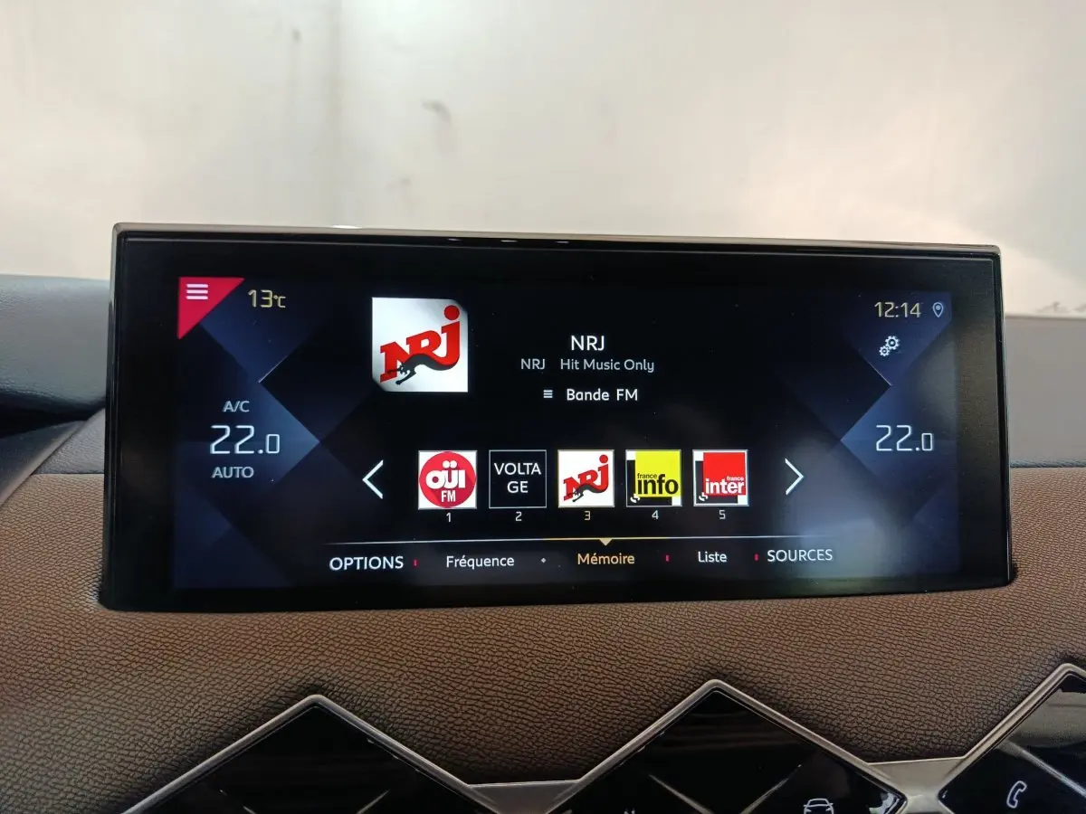 Écran tactile central du tableau de bord du DS3 Crossback gris foncé affichant la radio NRJ à 12h14