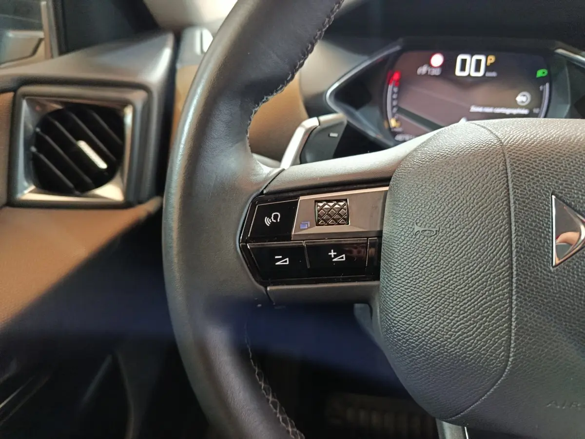 Gros plan sur le volant cuir noir côté gauche du DS3 Crossback 2020 avec commandes vocales et tableau de bord numérique.
