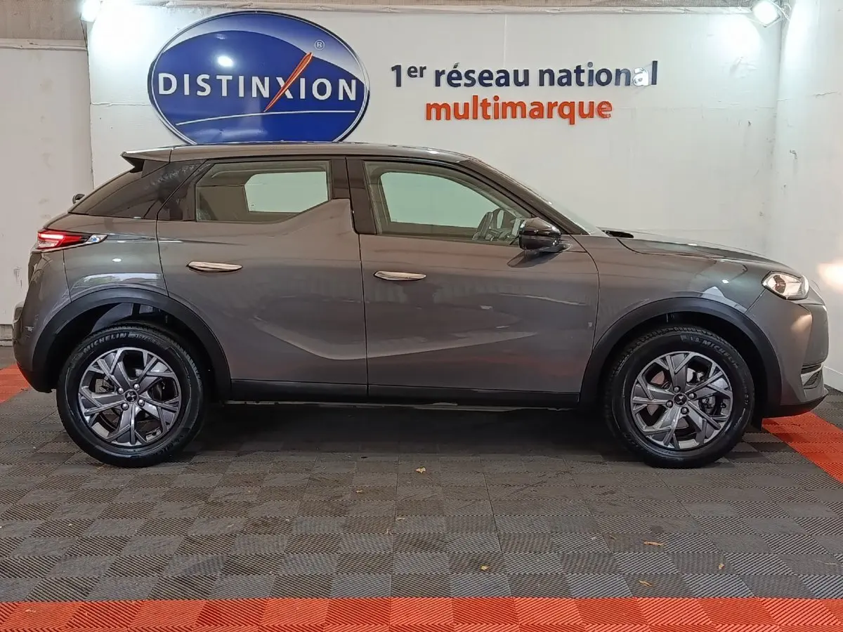 Profil côté gauche d'un DS3 Crossback gris foncé 2020, avec jantes alliage et poignées de porte intégrées au design.