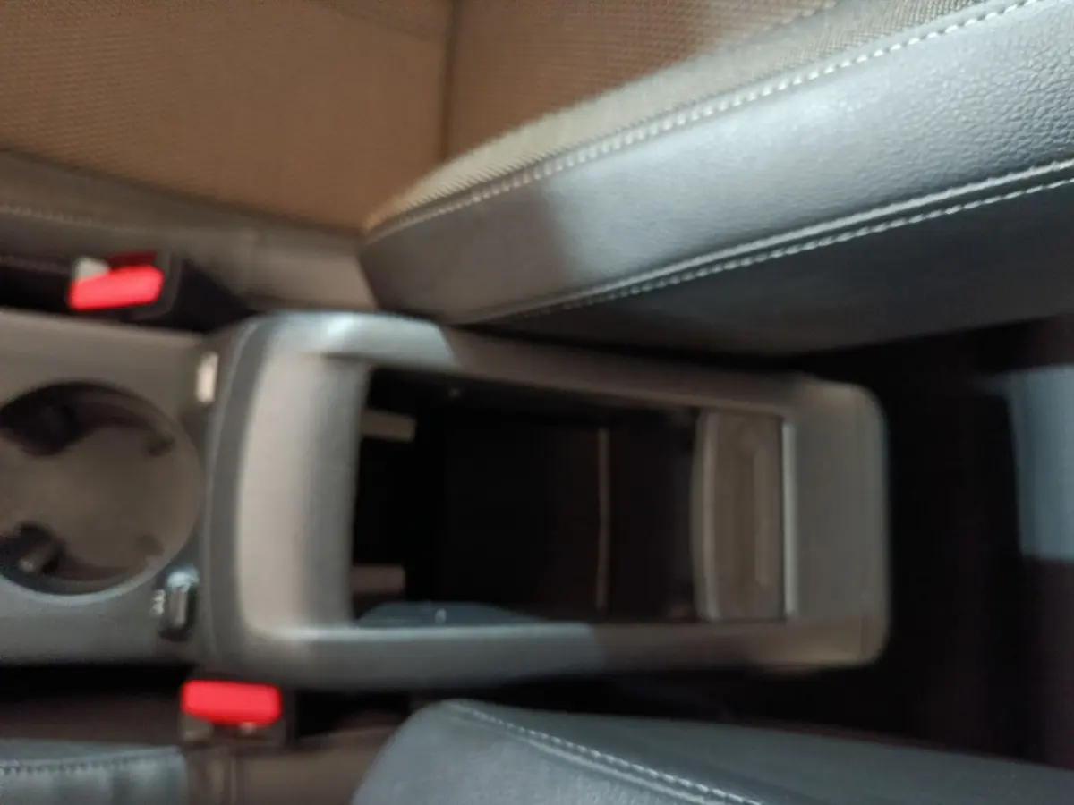 Gros plan sur la console centrale noire et les sièges en cuir gris foncé du DS3 Crossback PureTech 130 Automatique Business.
