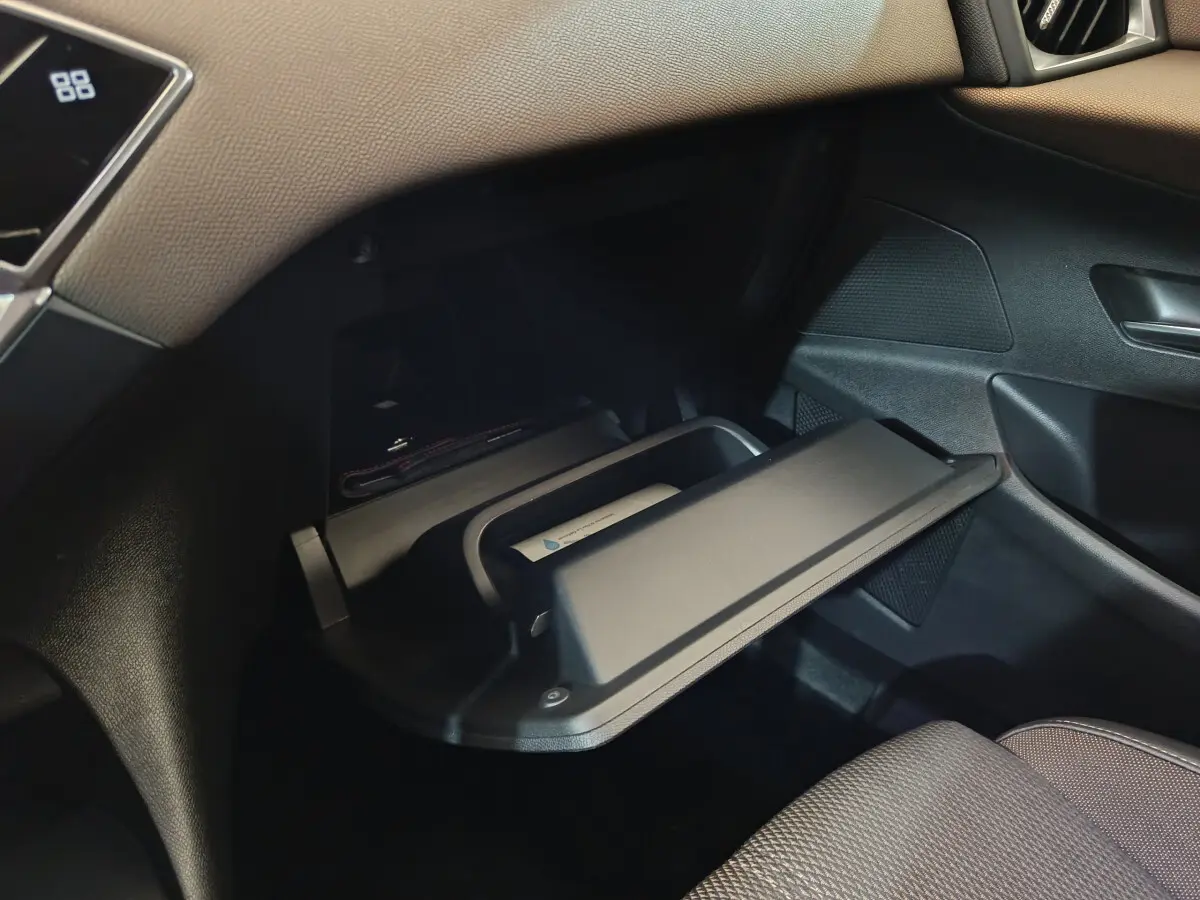 Gros plan sur la boîte à gants ouverte côté passager du DS3 Crossback gris foncé, intérieur noir texturé.