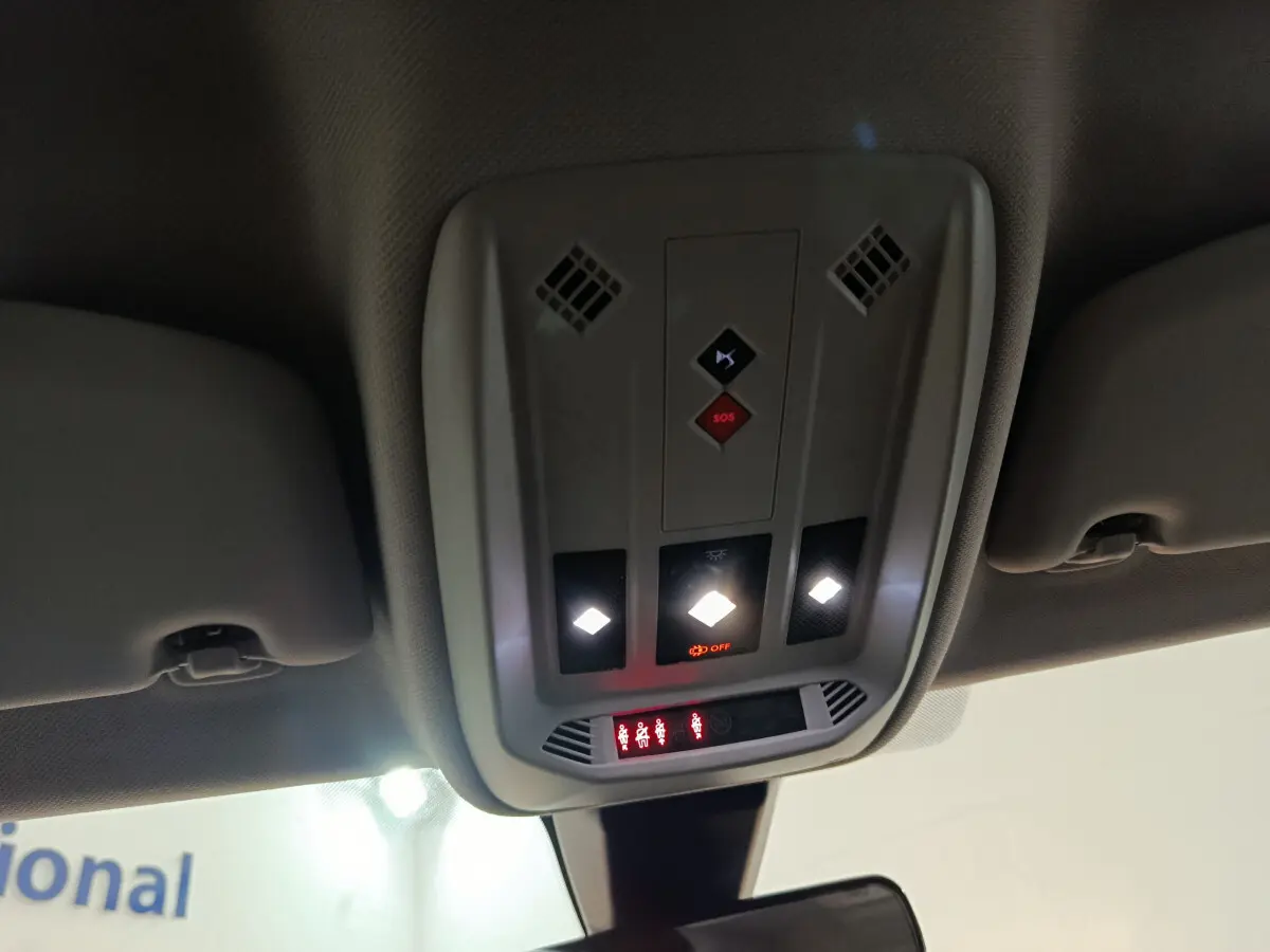 Plafonnier intérieur avec commandes lumineuses et boutons SOS du DS3 Crossback gris foncé, vue du siège conducteur vers l'avant.