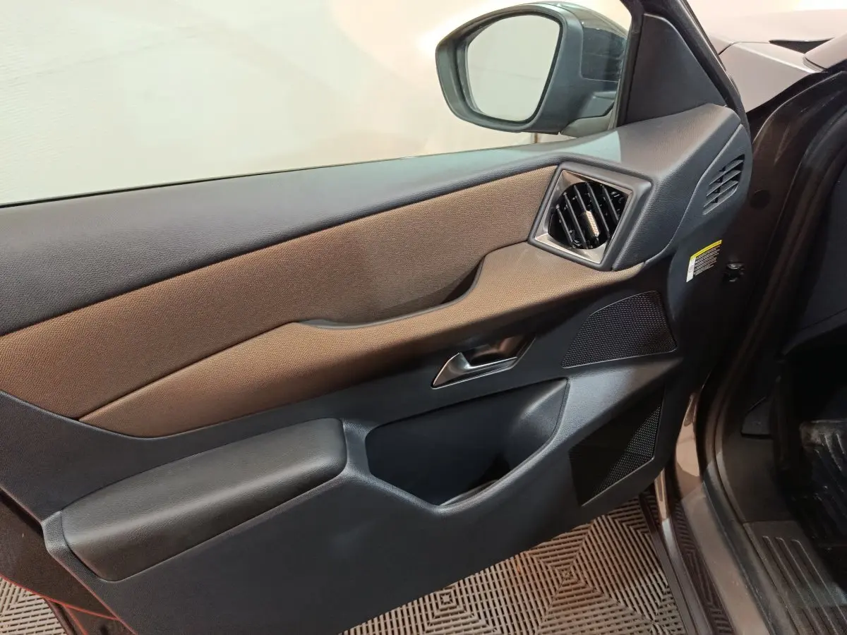 Vue intérieure du panneau de porte côté conducteur du DS3 Crossback gris foncé, avec commandes et haut-parleur intégrés.