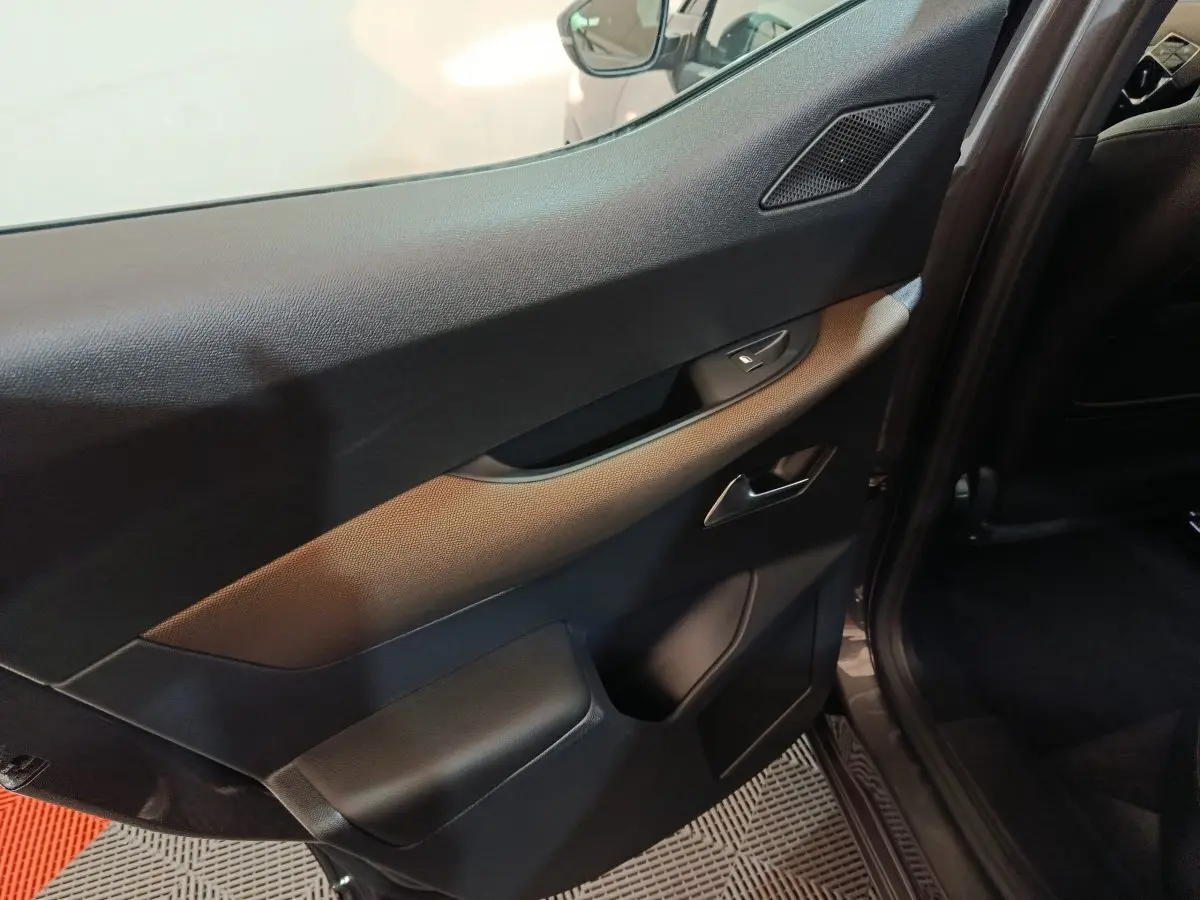 Vue rapprochée de la porte intérieure côté gauche gris foncé du DS3 Crossback 2020 avec poignée et commande de fenêtre.