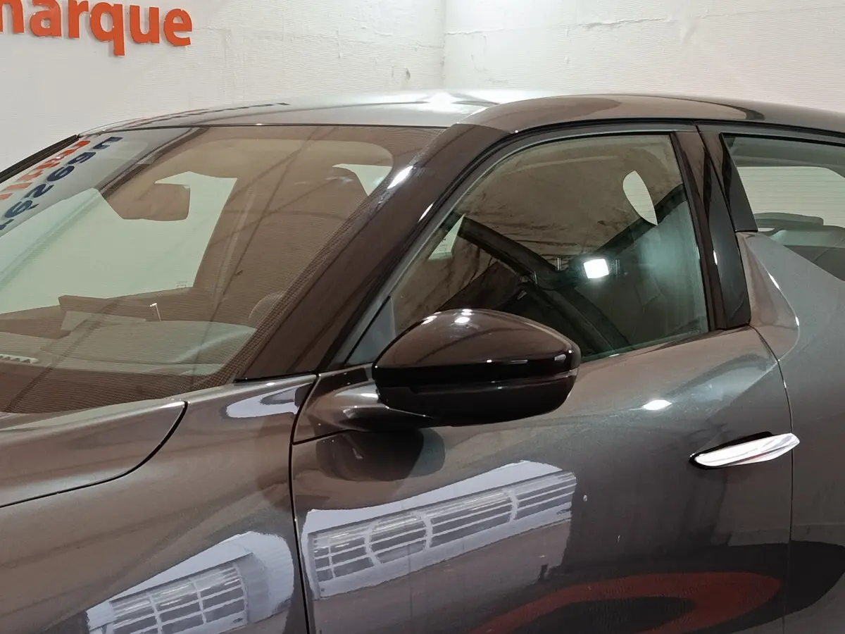 Vue de profil côté gauche sur la porte avant d'une DS3 Crossback gris foncé avec rétroviseur ton caisse brillant.