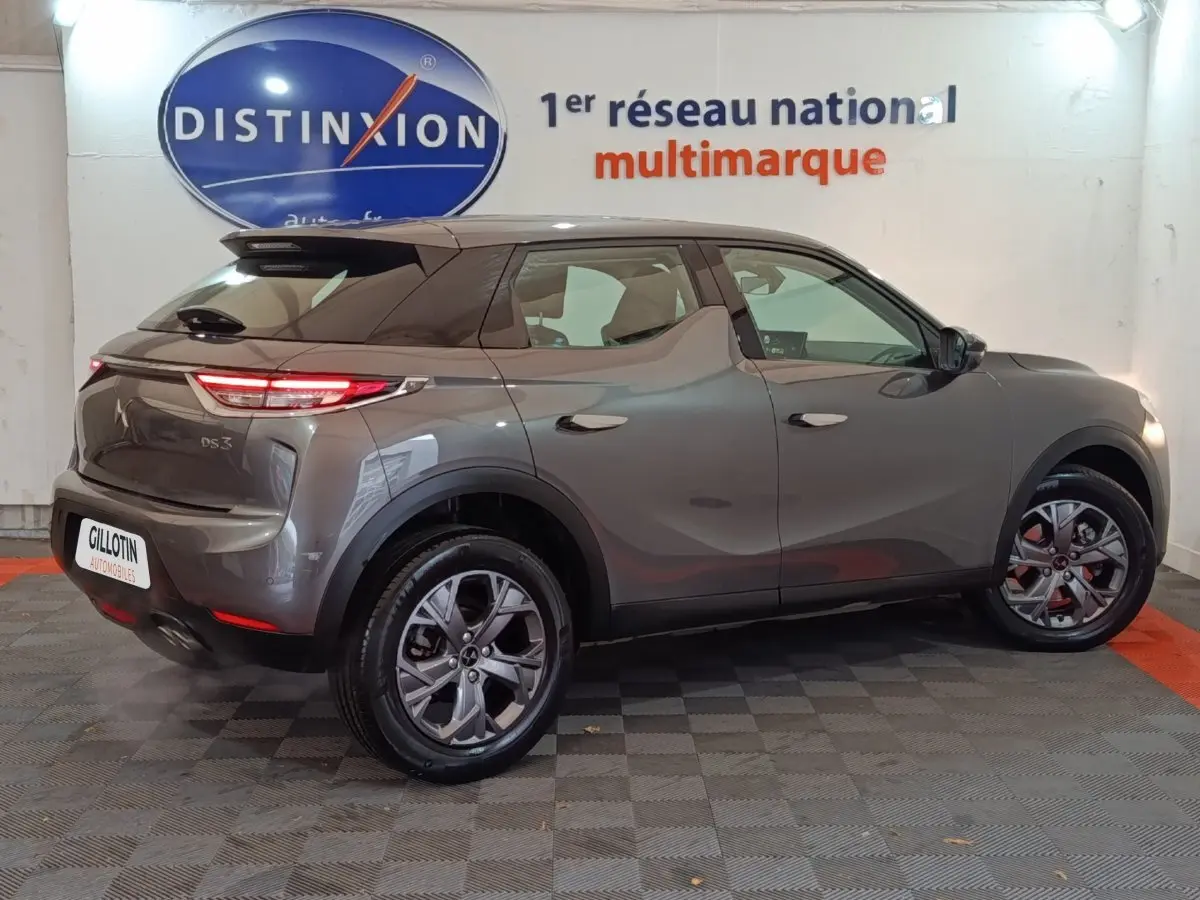 Vue 3/4 arrière droite d'un DS3 Crossback gris foncé, mettant en valeur ses feux arrière LED et ses jantes modernes.