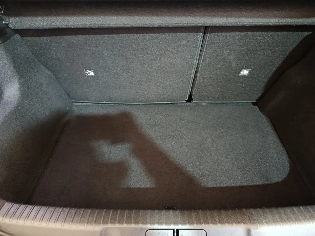 Coffre vide en vue plongeante du DS3 Crossback gris foncé, montrant la banquette arrière rabattable et le revêtement intérieur.
