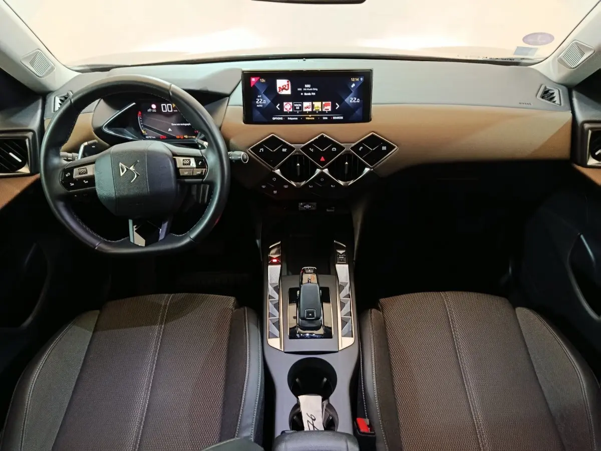 Intérieur DS3 Crossback vu de face, tableau de bord beige et noir avec écran tactile 10,3 pouces et volant cuir multifonction.