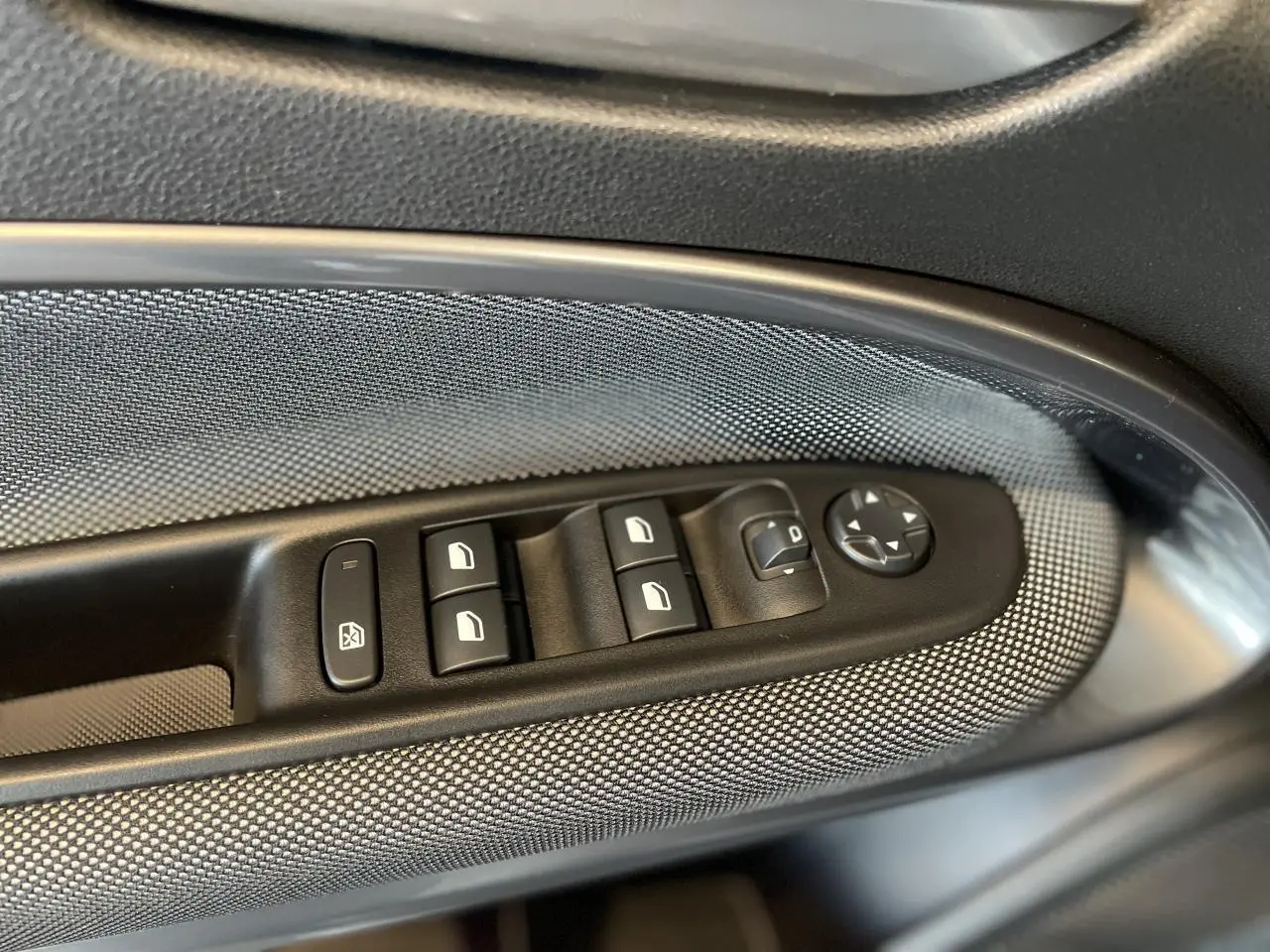 Gros plan sur les commandes de lève-vitres et rétroviseurs côté gauche de la FIAT 600 beige métallisé 2025.