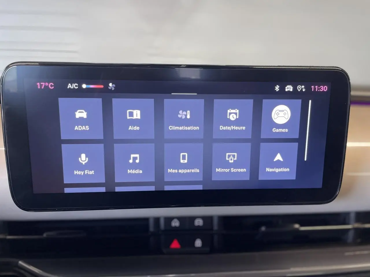 Écran tactile central du tableau de bord beige métallisé de la Fiat 600 Hybrid affichant les options multimédia et climatisation.