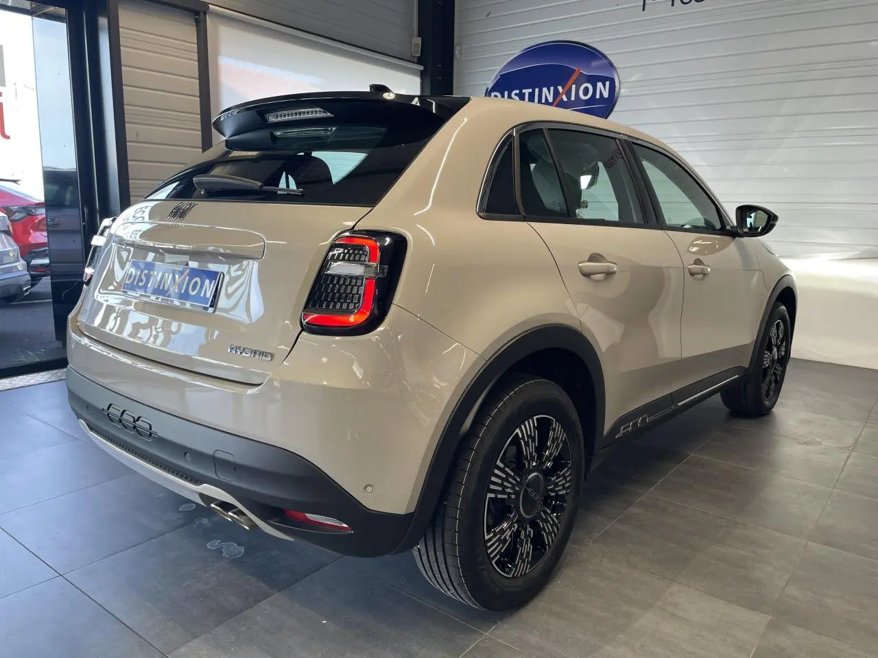 Vue 3/4 arrière droite d'une FIAT 600 beige métallisé avec jantes alliage noires et feux arrière LED distinctifs.