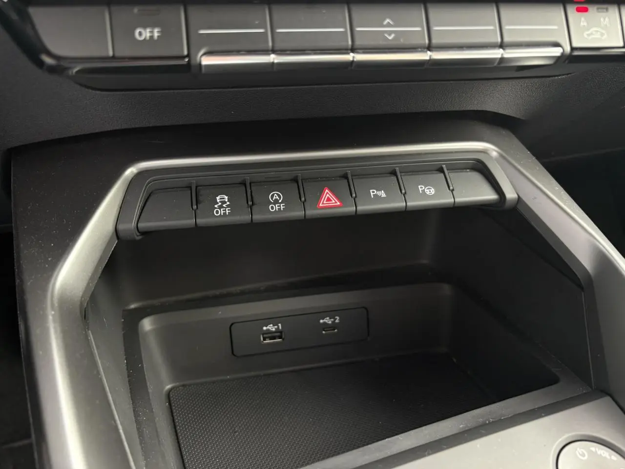 Gros plan sur la console centrale de l'Audi A3 Berline gris, montrant les boutons de contrôle et ports USB.