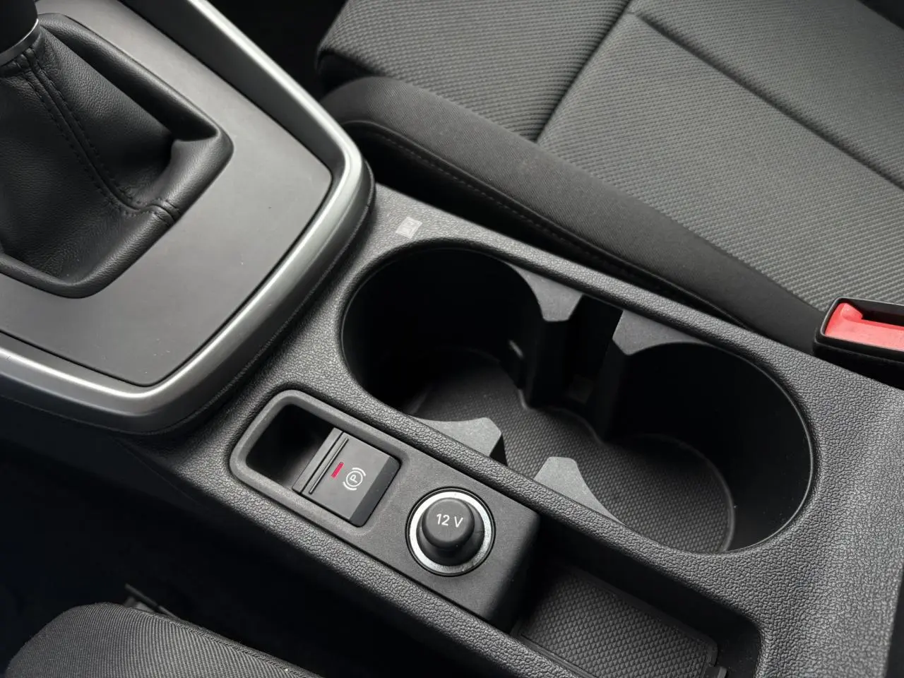 Gros plan sur la console centrale de l'Audi A3 Berline gris, avec levier de vitesses manuel et porte-gobelets.