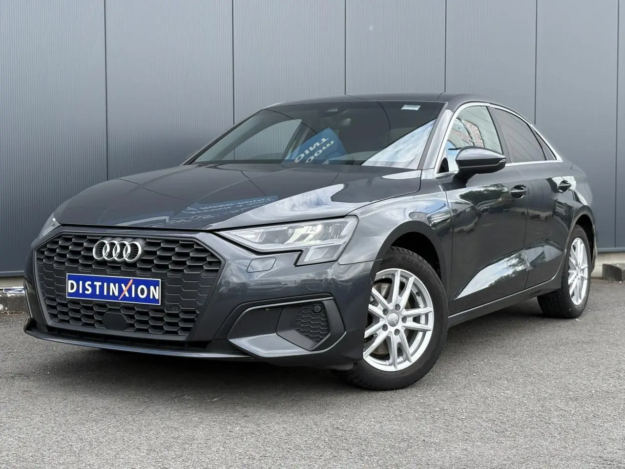 Audi A3 Berline gris métallisé vue 3/4 avant droit avec calandre hexagonale et jantes argentées