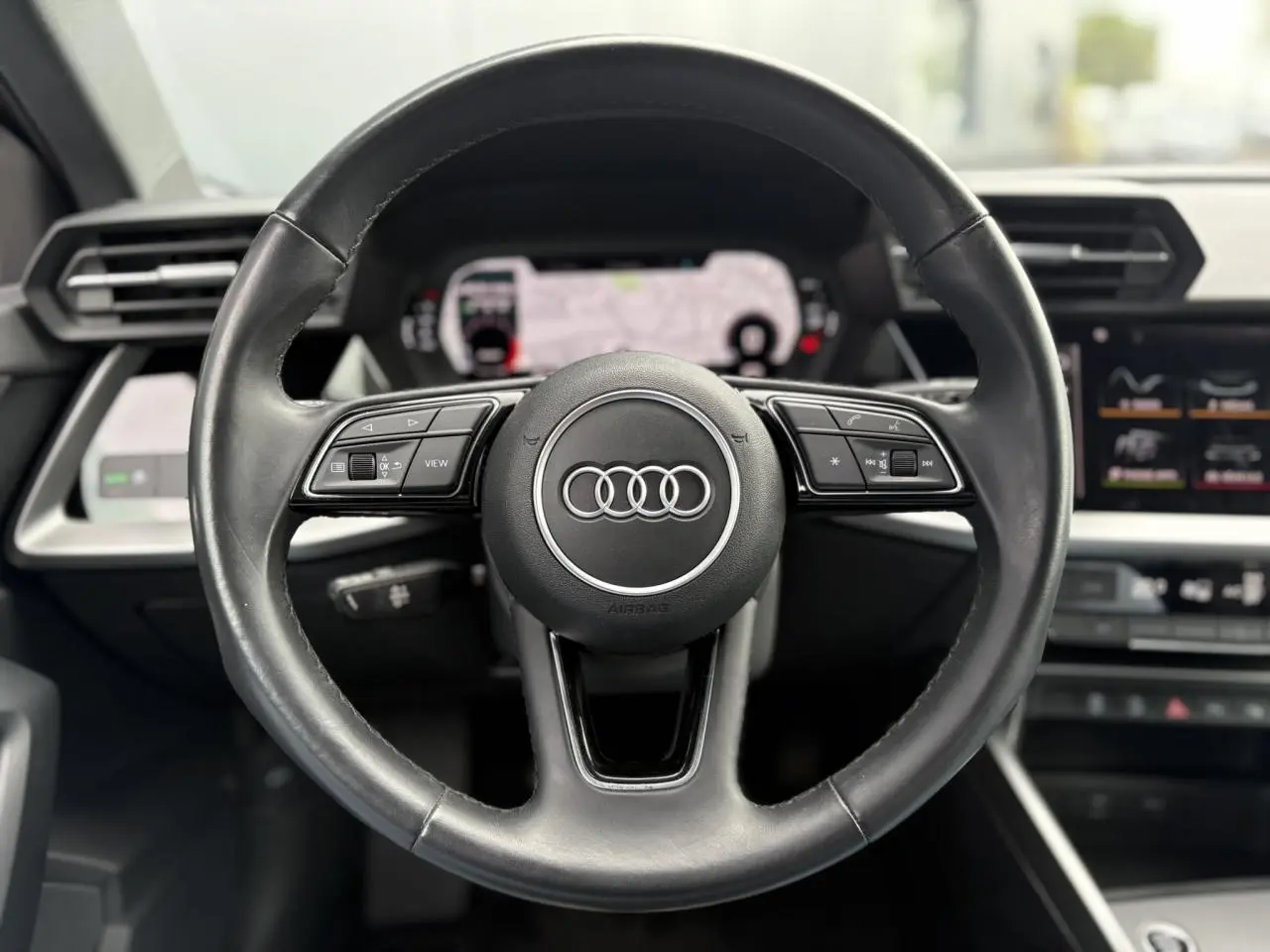 Volant cuir multifonctions Audi A3 Berline 35 TFSI 2020 vu de face avec tableau de bord numérique et écran central.