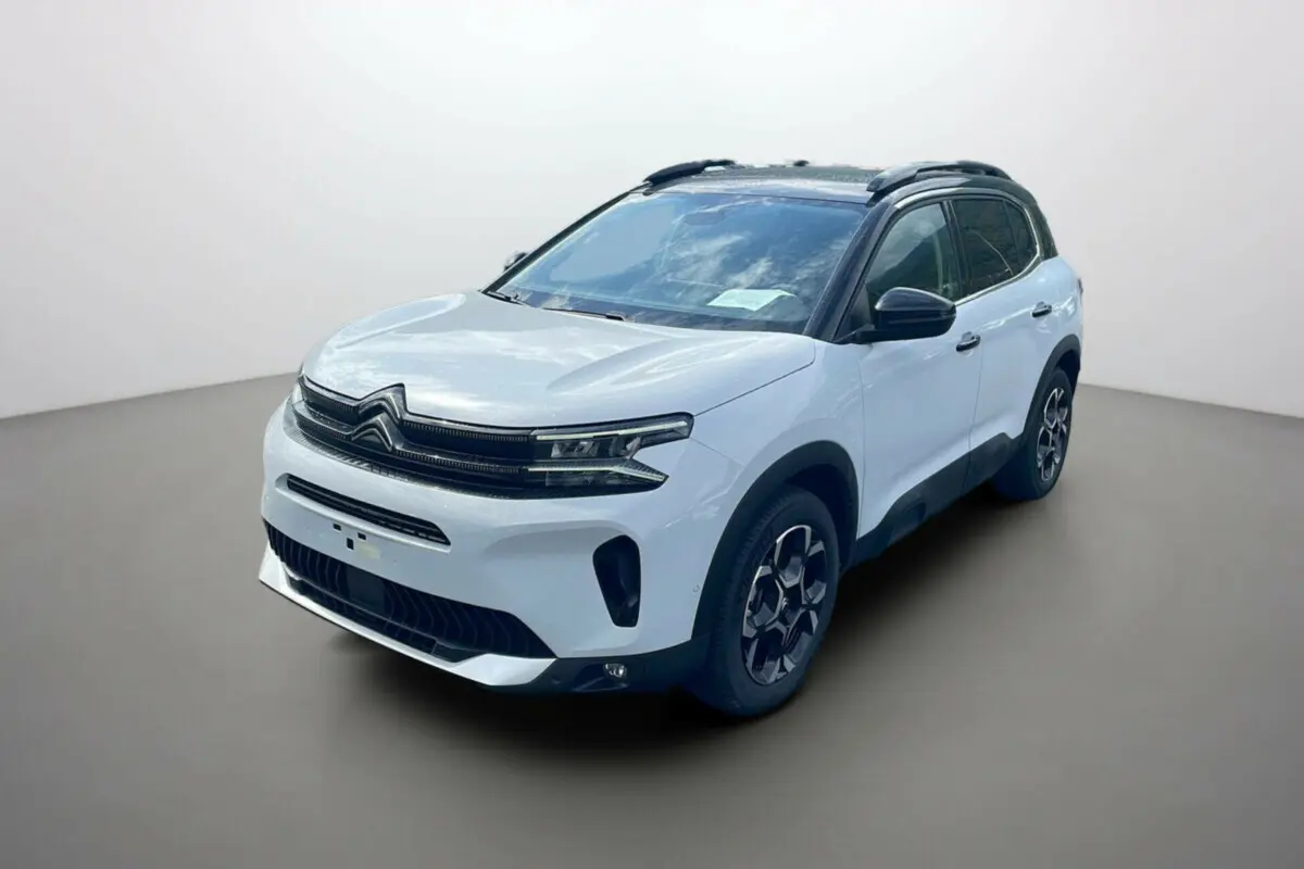 Citroën C5 Aircross Hybrid 2025 blanc okénite avec toit noir, vue 3/4 avant côté droit sur fond neutre.