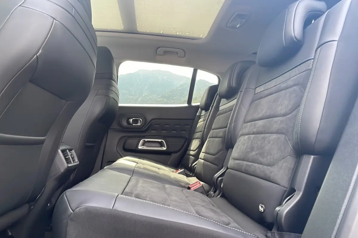 Vue intérieure côté droit des sièges arrière en cuir noir du Citroën C5 Aircross Hybrid 2025 avec toit panoramique.