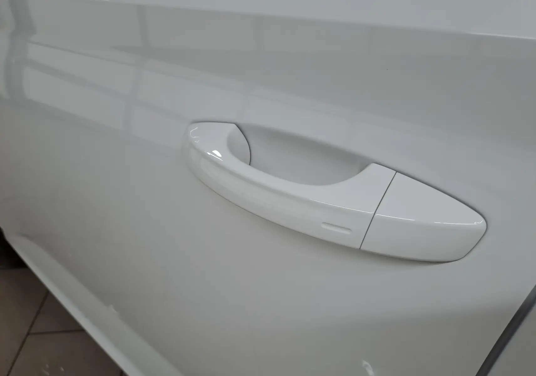 Poignée de porte blanche Lune en gros plan sur le côté gauche du Skoda Kamiq 2025 finition Selection.