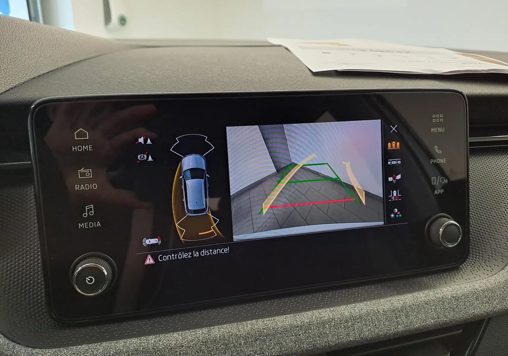 Écran tactile intérieur du Skoda Kamiq 2025 montrant la caméra de recul et les radars de stationnement.