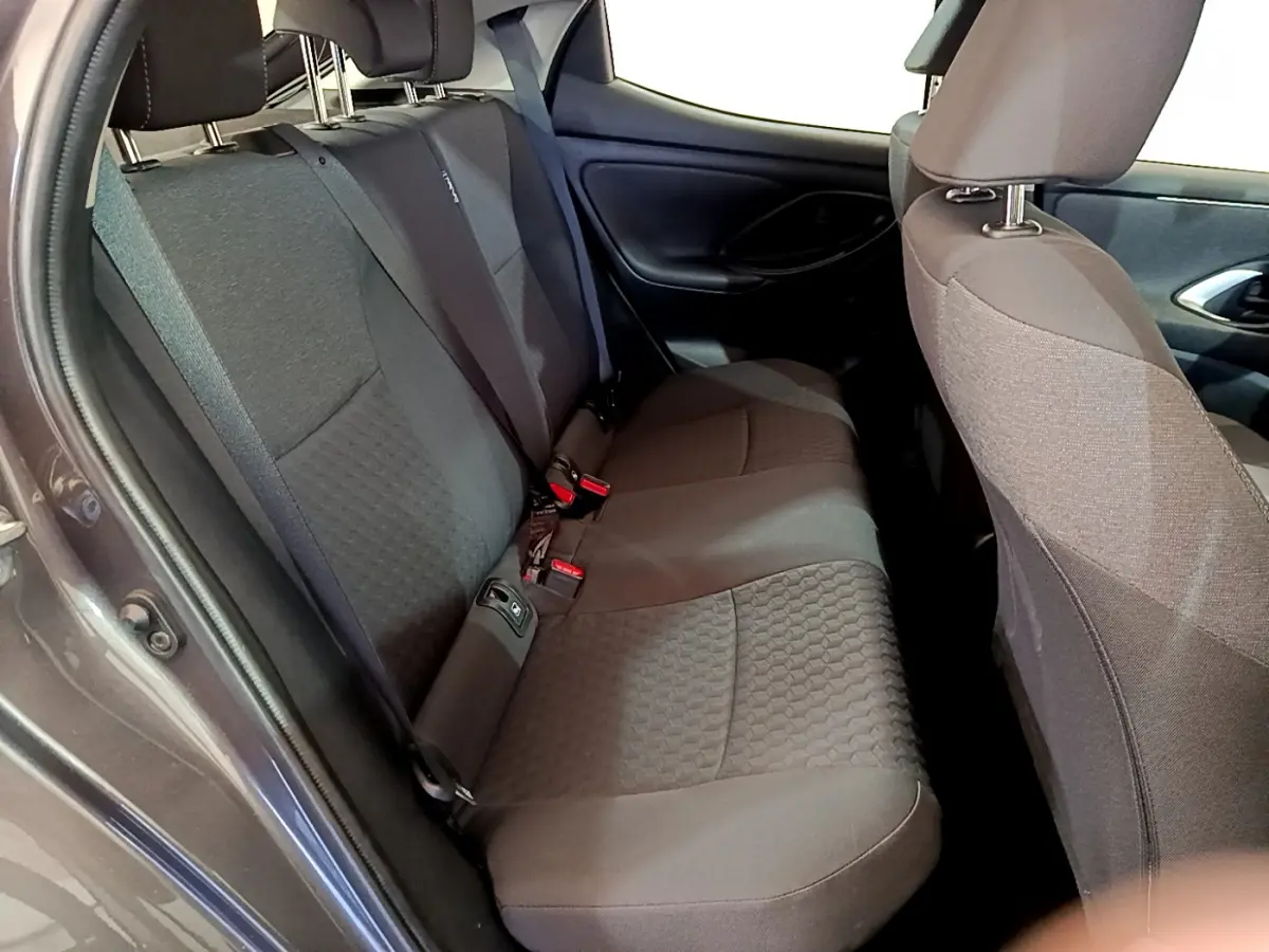Vue intérieure du siège arrière côté gauche d'une Toyota Yaris hybride gris clair avec tissu texturé.