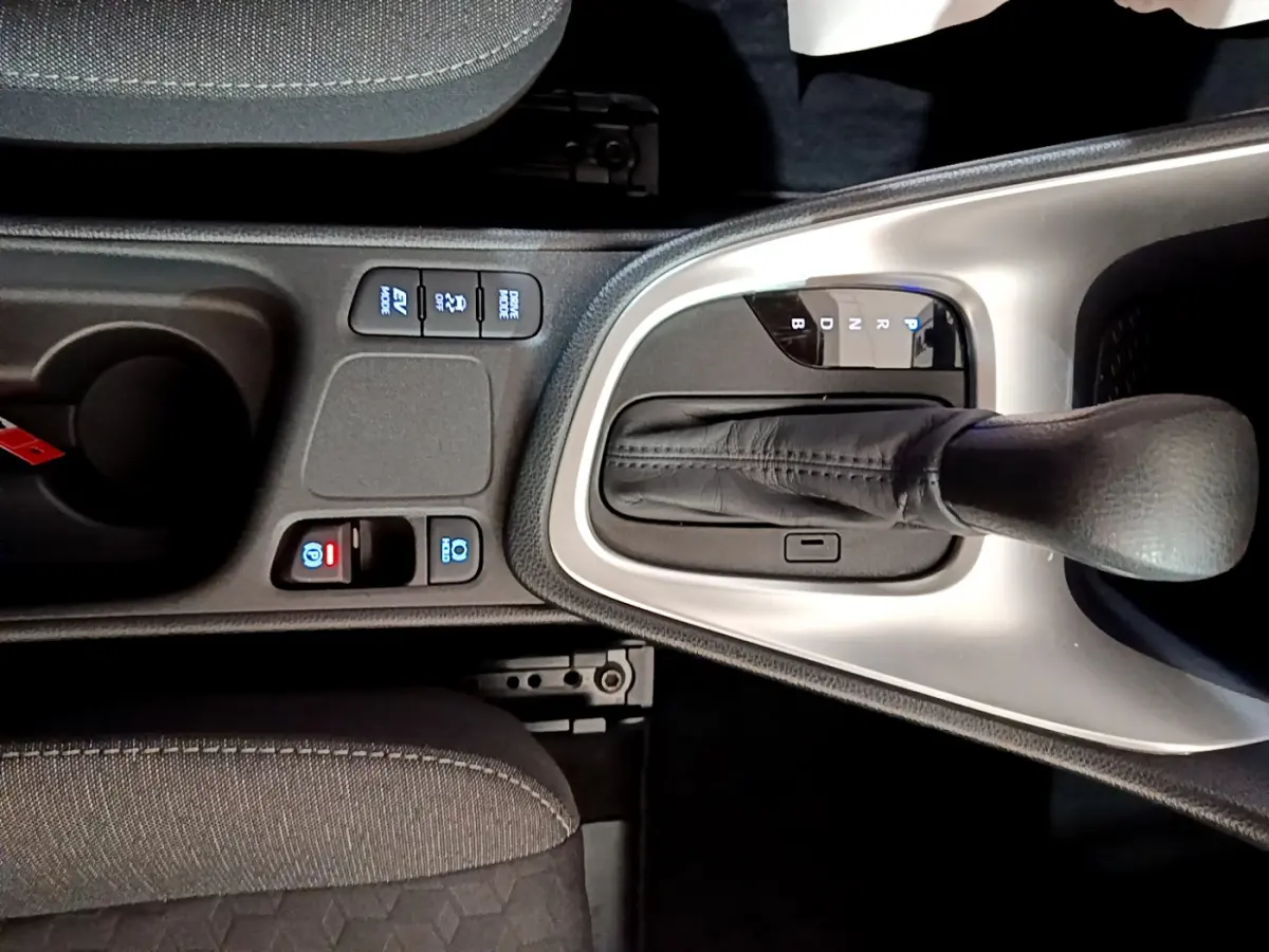 Gros plan sur la console centrale de la Toyota Yaris hybride 2021, montrant le levier de vitesse automatique et les boutons de commande.