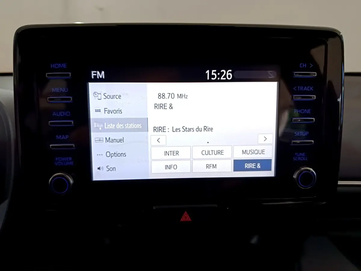 Écran tactile central de la Toyota Yaris hybride 2021 affichant la liste des stations radio FM en intérieur noir.