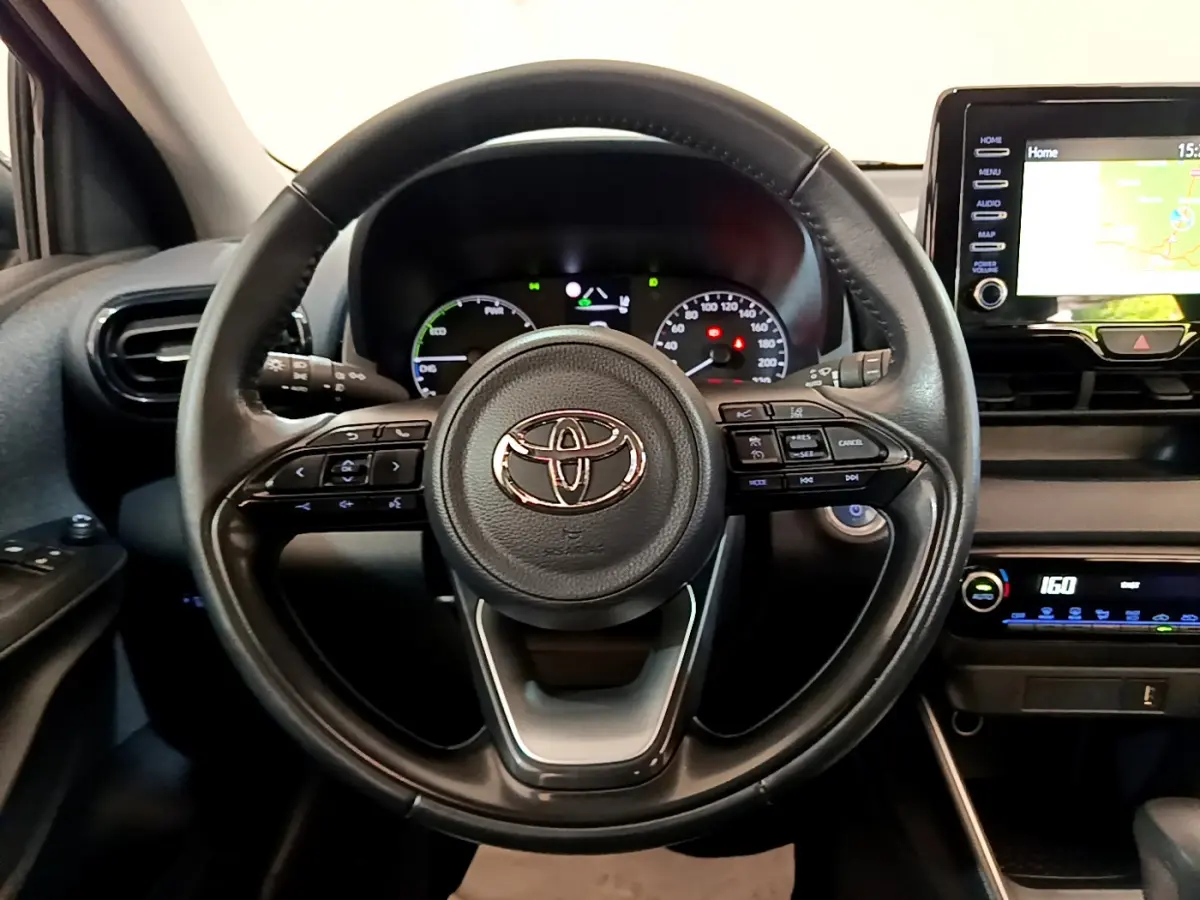 Vue rapprochée du volant cuir multifonctions noir et du tableau de bord digital de la Toyota Yaris hybride 2021.