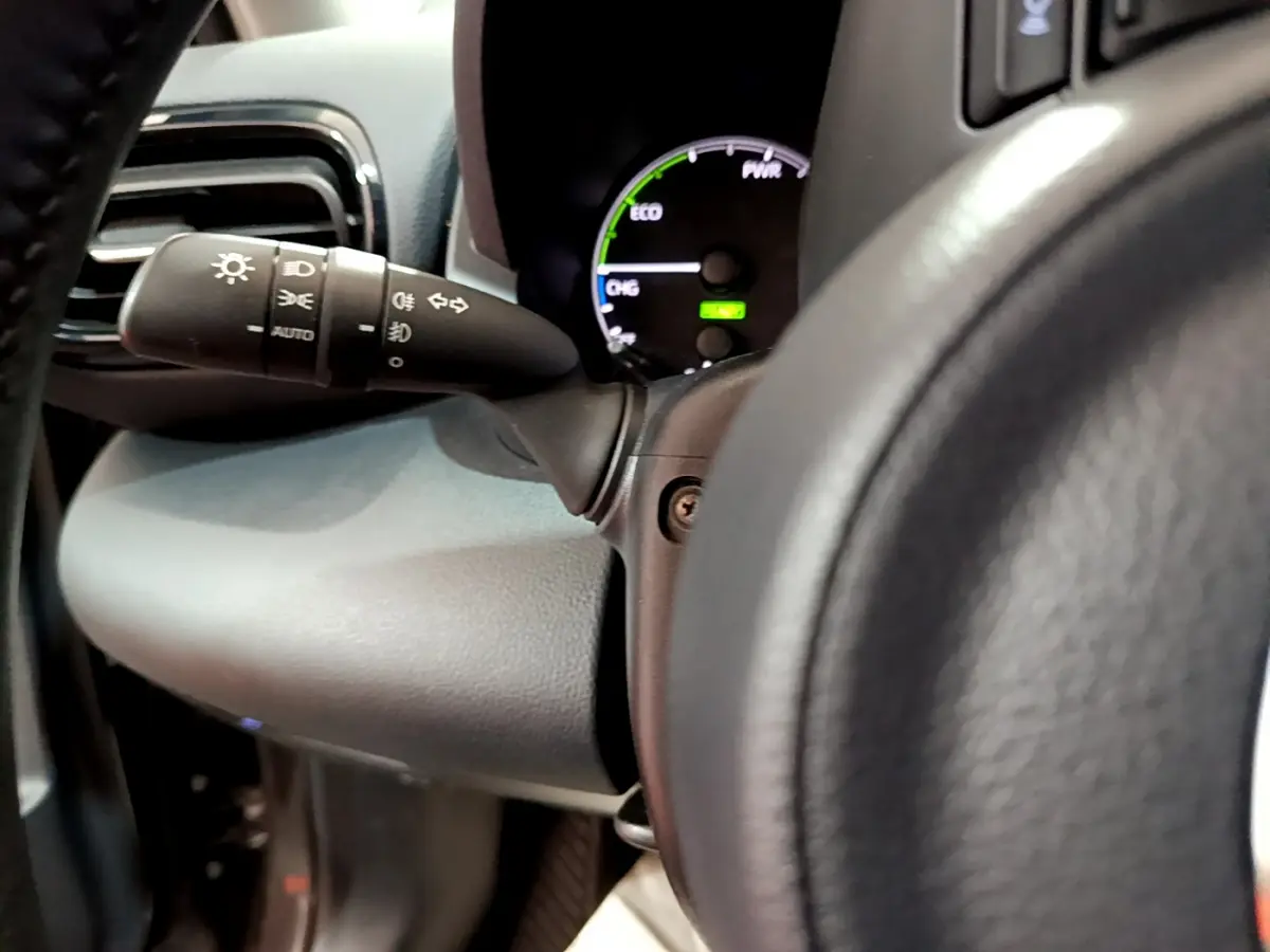 Gros plan sur le commodo d’éclairage et le tableau de bord numérique de la Toyota Yaris hybride 2021.