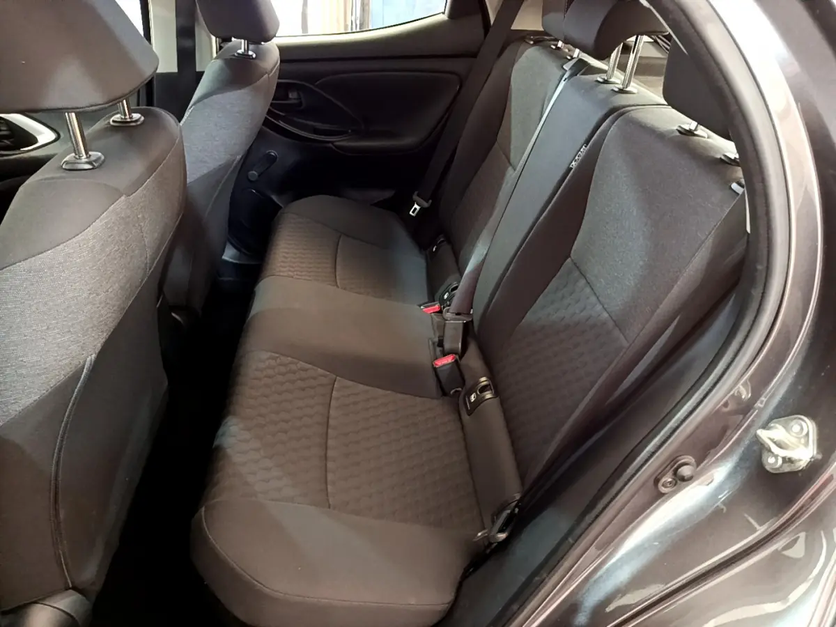 Vue intérieure côté droit des sièges arrière gris foncé de la Toyota Yaris hybride 2021, avec ceintures et appuie-têtes visibles.