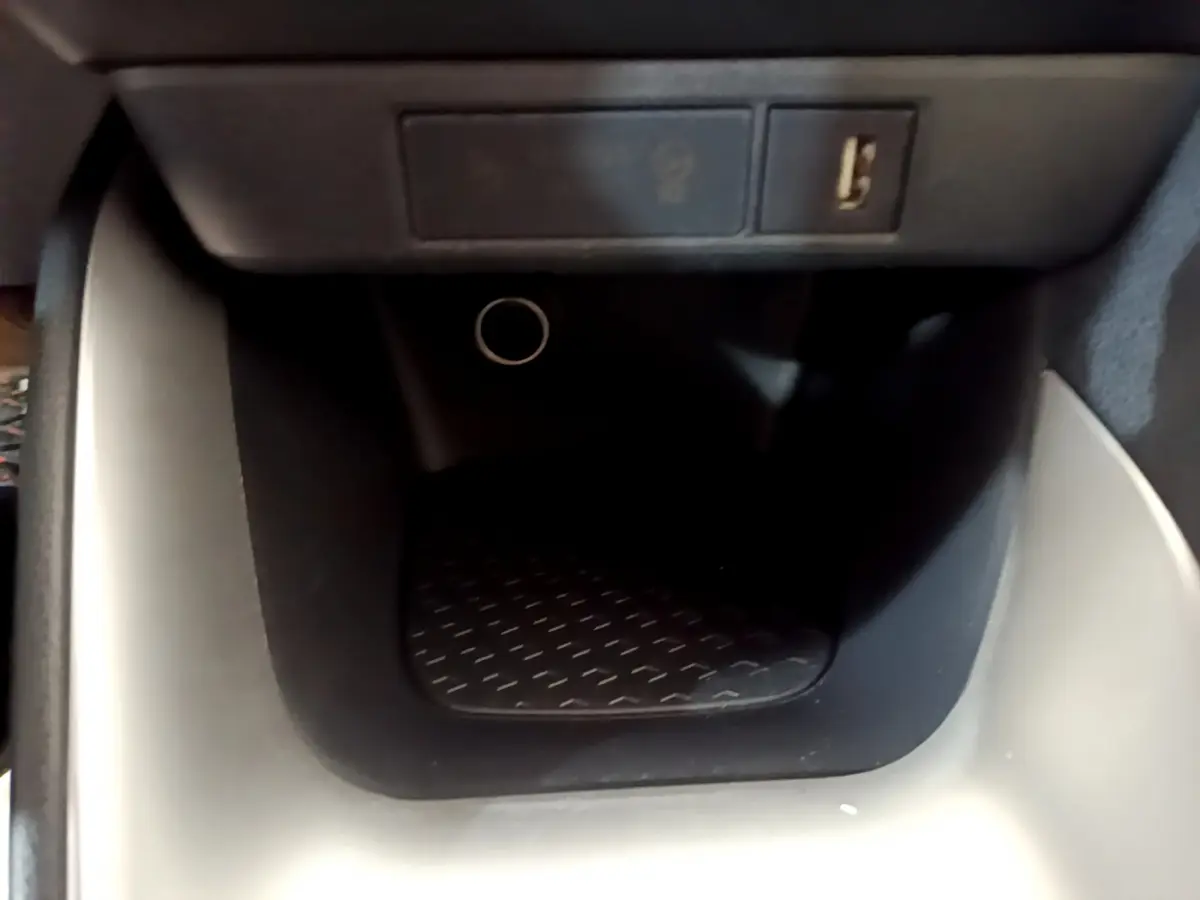 Gros plan sur la prise USB et l’allume-cigare dans le rangement central noir de la Toyota Yaris hybride gris clair 2021.