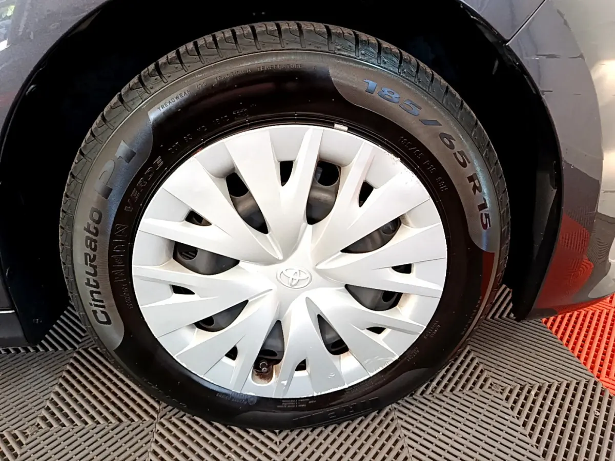 Gros plan sur la roue avant droite gris clair de la Toyota Yaris Hybride 116h avec enjoliveur blanc et pneu Cinturato P1.