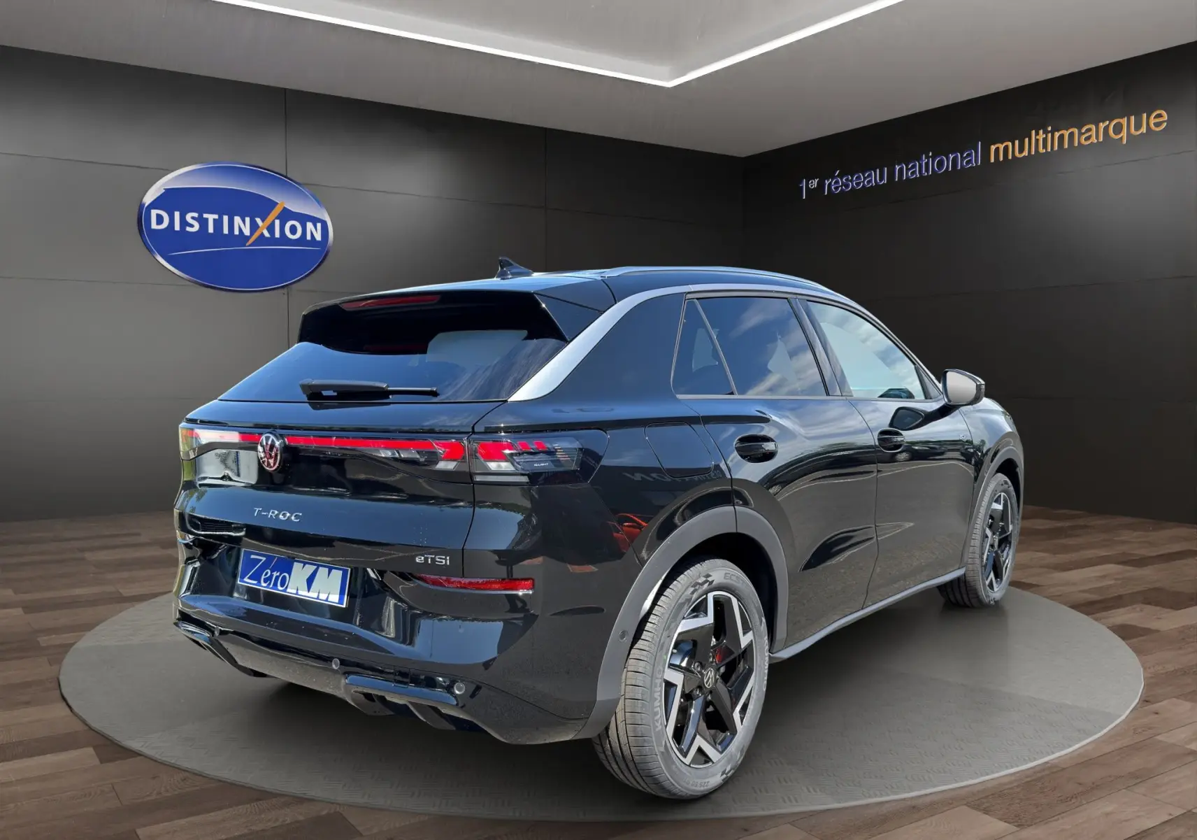 Vue 3/4 arrière droite du Volkswagen T-Roc noir ébène 2026 avec finition R-Line, attelage et feux LED distinctifs.