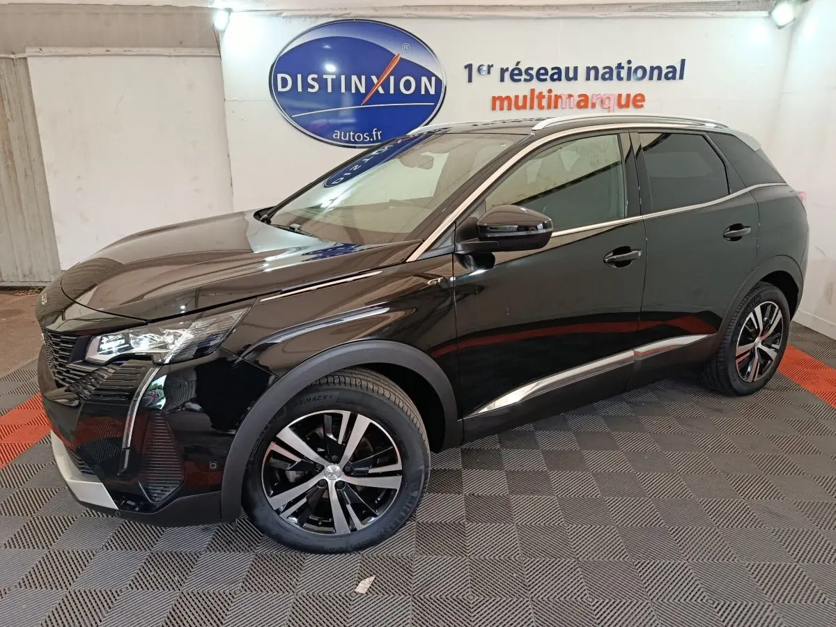 Peugeot 3008 PureTech 130 GT noir vue de profil droit en intérieur avec jantes alliage et toit chromé.