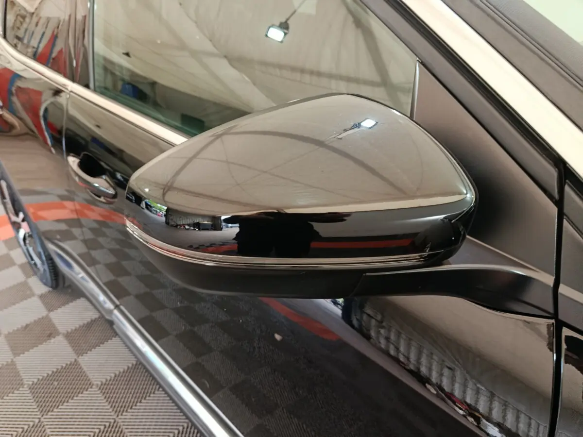 Rétroviseur côté gauche noir brillant du Peugeot 3008 PureTech 130 GT, avec porte et poignée visibles en arrière-plan.