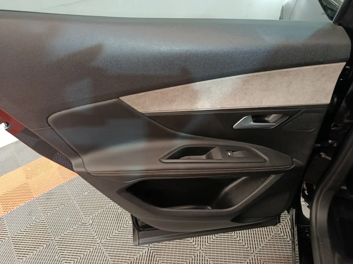 Vue intérieure de la porte arrière gauche noire du Peugeot 3008 2022, avec garniture tissu et plastique.