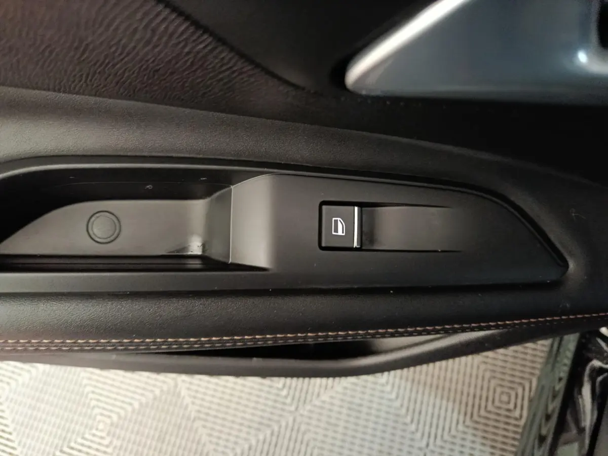 Détail de la commande de condamnation centralisée sur la porte intérieure côté gauche du Peugeot 3008 noir 2022.