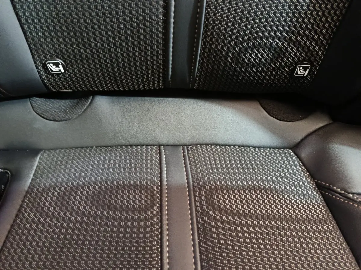 Gros plan sur la banquette arrière noire du Peugeot 3008 avec logos Isofix visibles sur les dossiers des sièges.