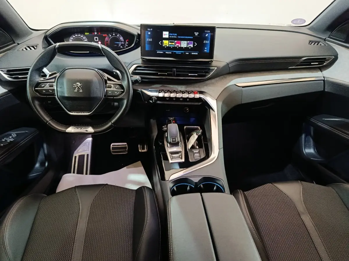 Vue intérieure avant du Peugeot 3008 noir 2022, tableau de bord numérique et écran tactile central lumineux.