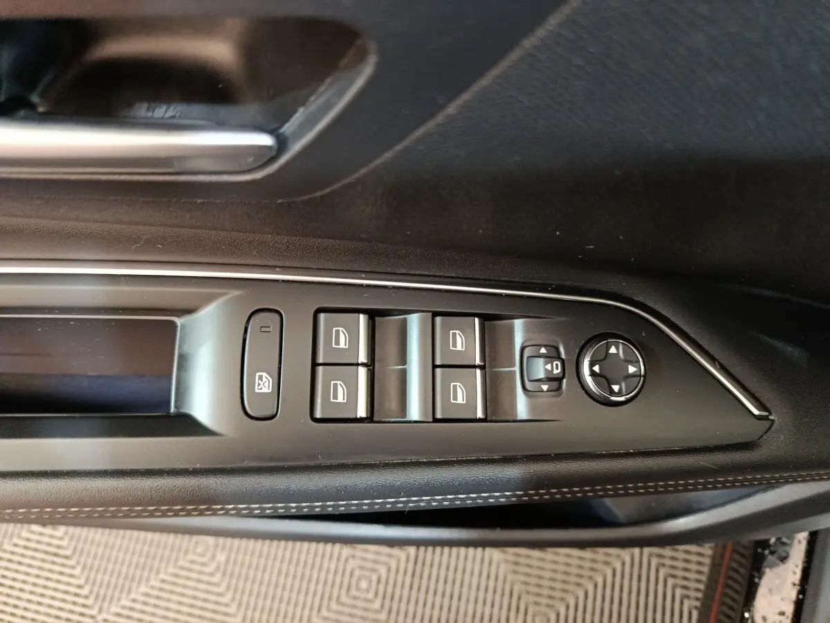 Gros plan sur les commandes des lève-vitres et rétroviseurs côté gauche noir du Peugeot 3008 PureTech 130 GT 2022.