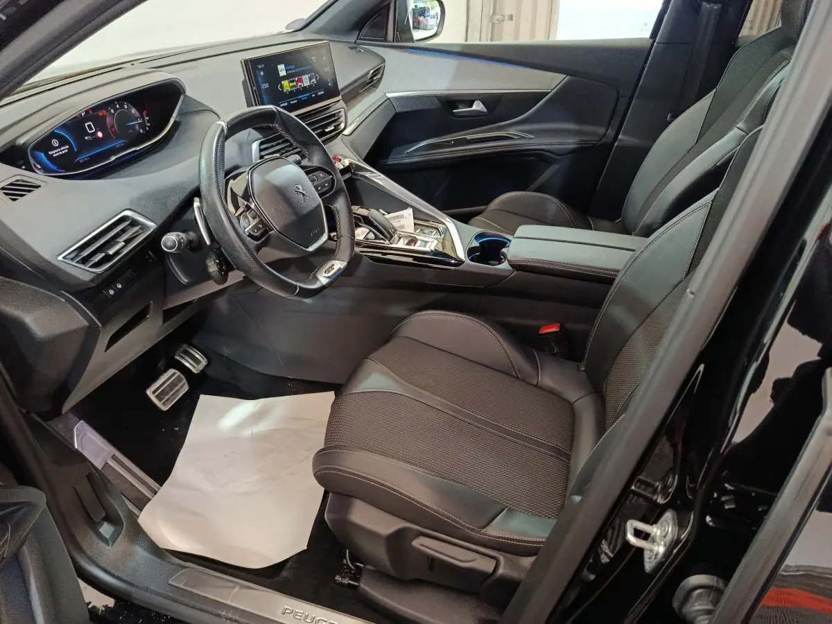 Intérieur noir du Peugeot 3008 GT 2022 vu côté conducteur, avec tableau de bord digital et volant cuir compact.