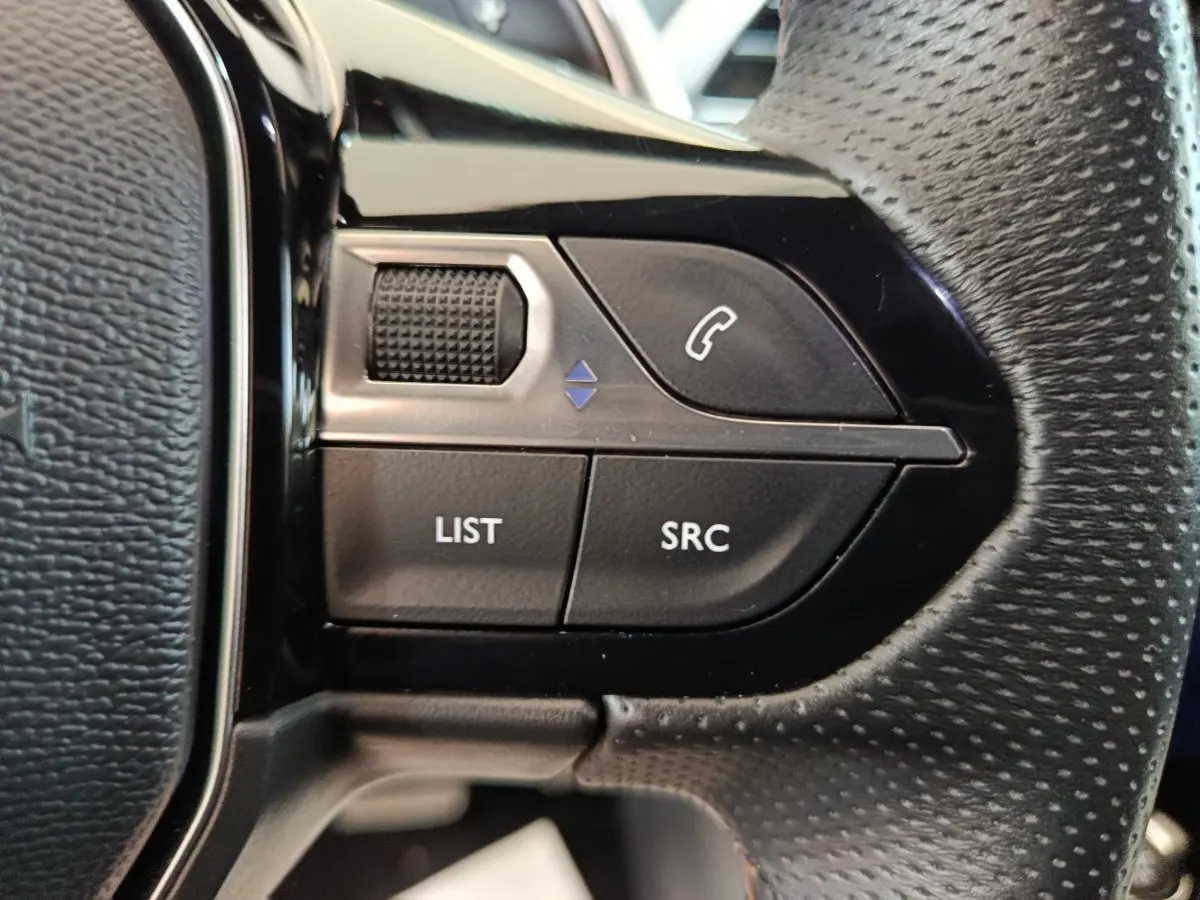 Gros plan sur les commandes gauche du volant en cuir perforé du Peugeot 3008 noir PureTech 130 GT 2022.