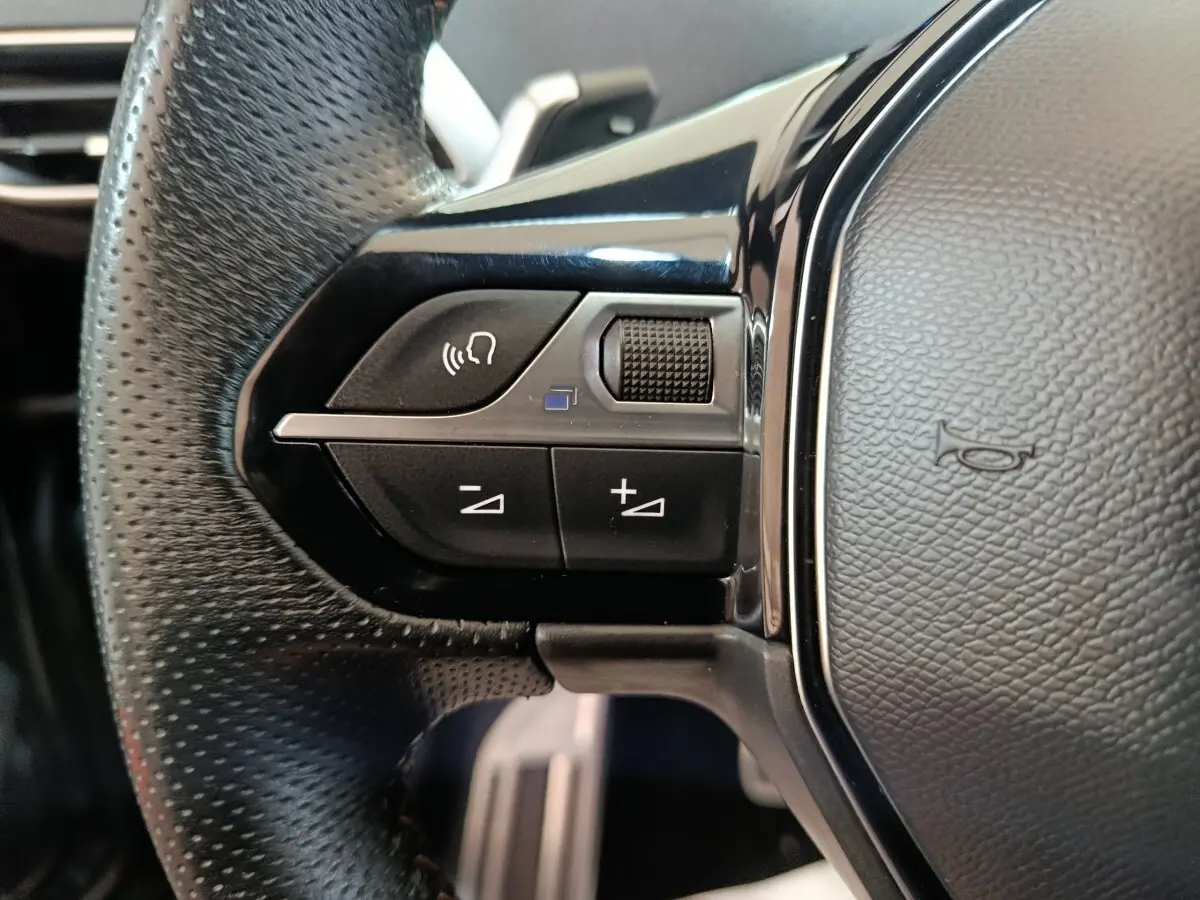 Gros plan sur les commandes gauche du volant cuir noir du Peugeot 3008 PureTech 130 GT 2022.