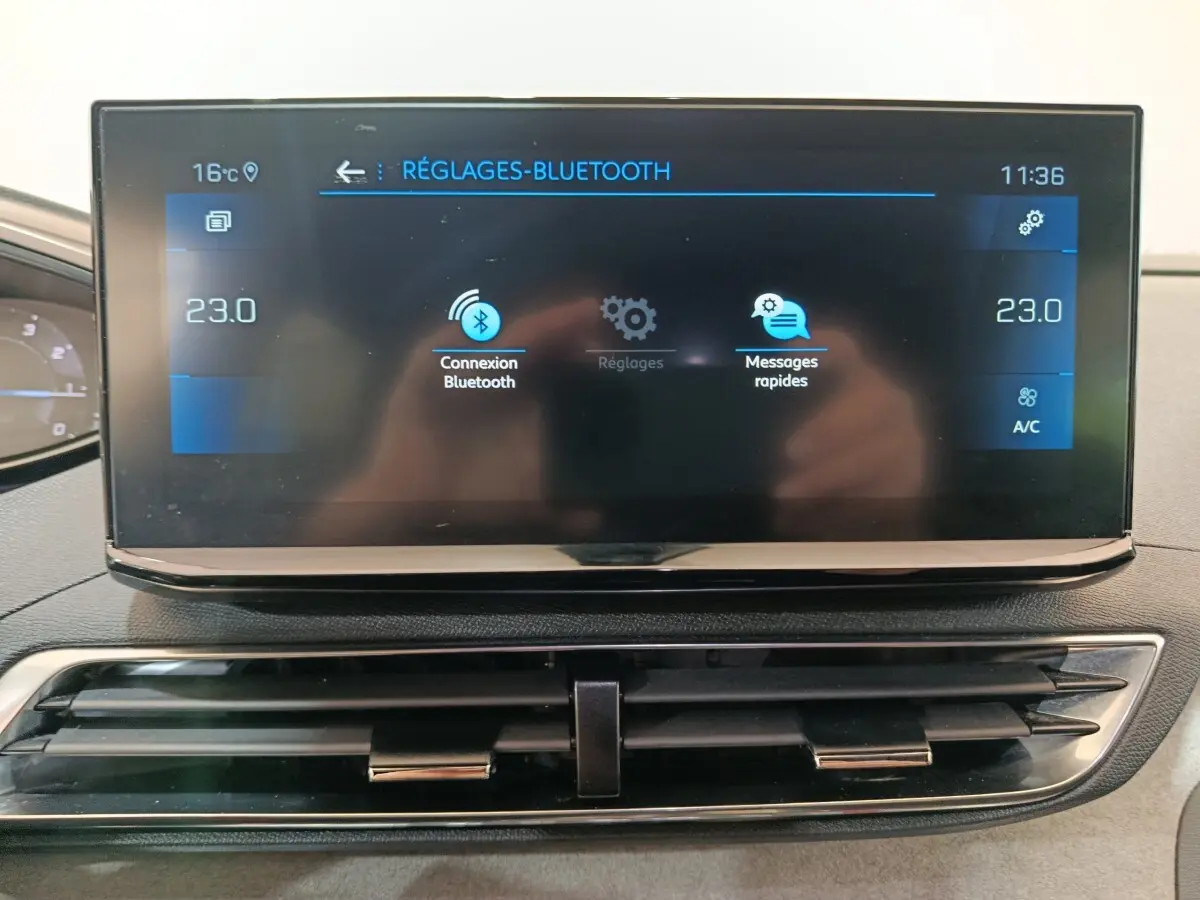 Écran tactile central du tableau de bord du Peugeot 3008 noir, affichant les réglages Bluetooth et température à 23°C.