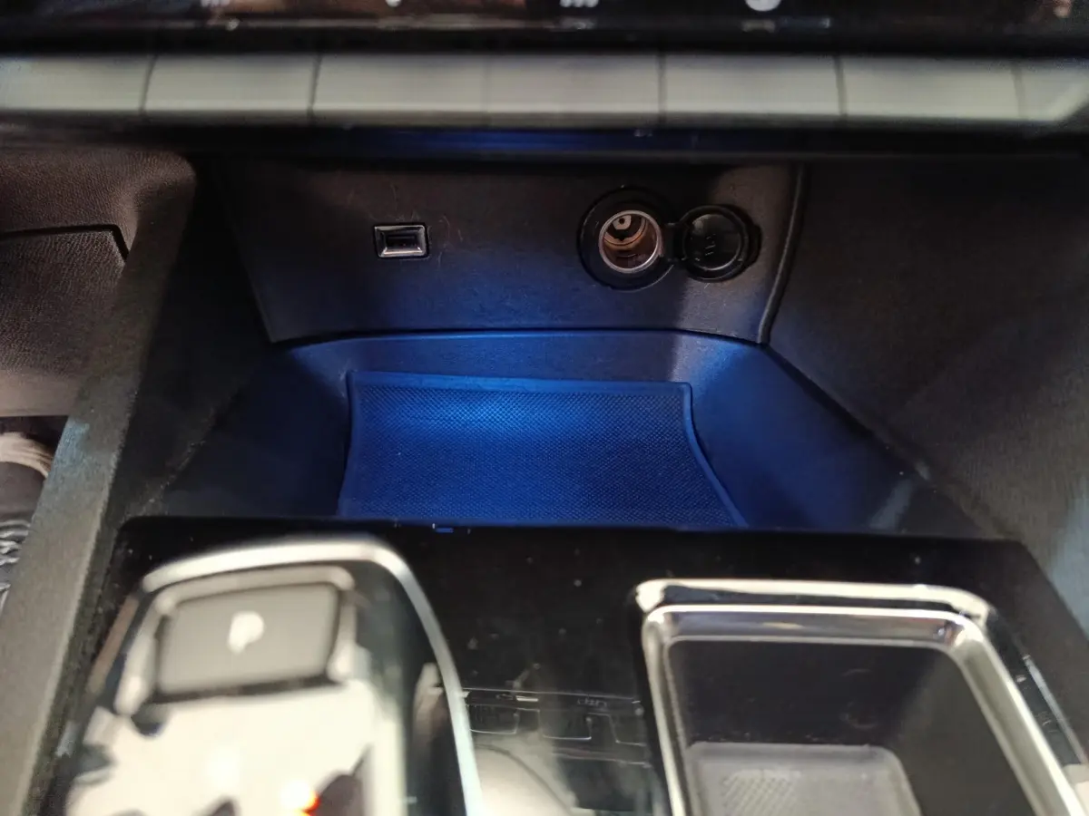 Gros plan sur la console centrale noire du Peugeot 3008 GT 2022, avec prise USB et allume-cigare visibles.