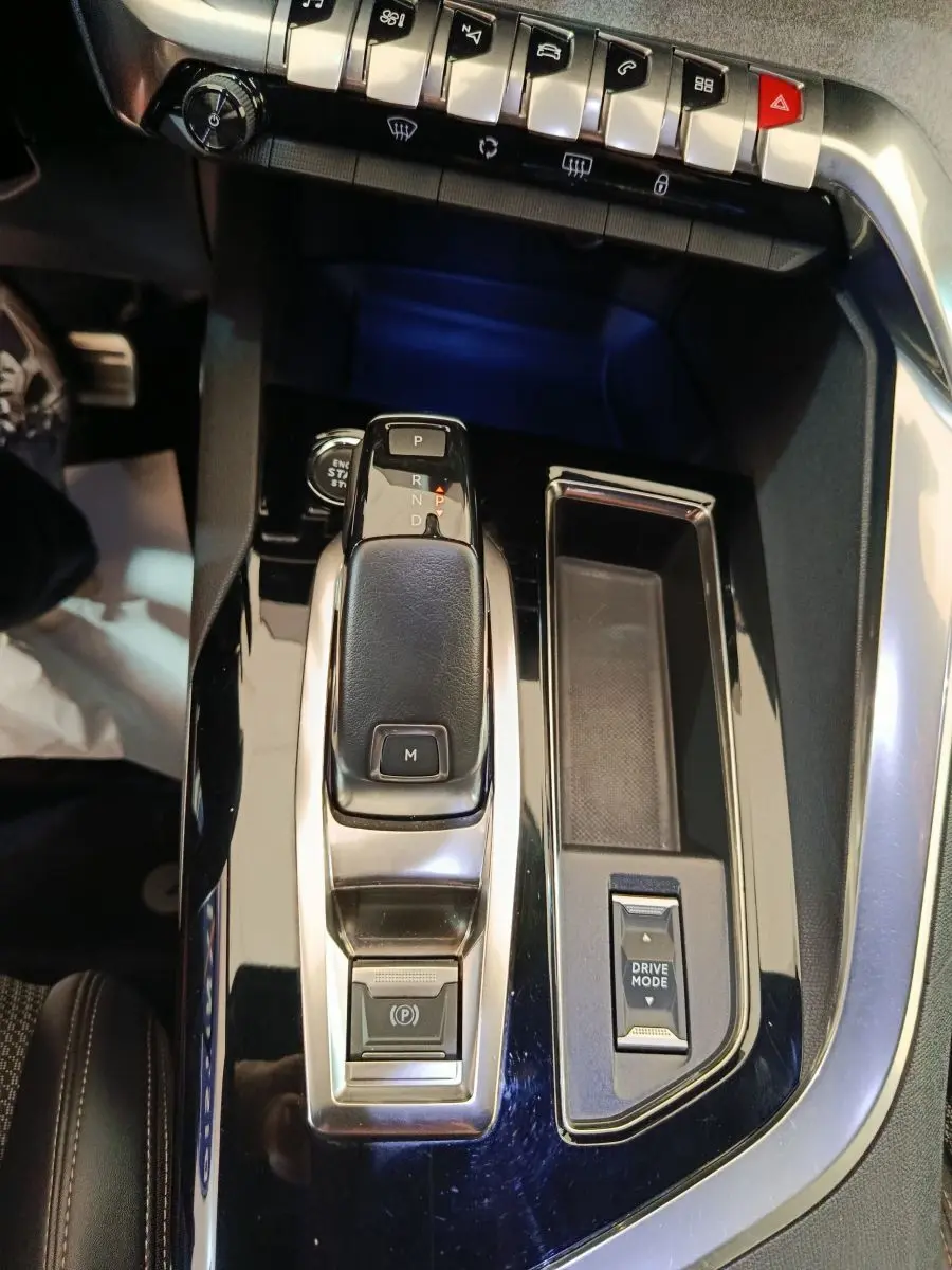 Vue rapprochée de la console centrale noire du Peugeot 3008 GT 2022 avec levier de vitesses automatique et commandes Drive Mode.