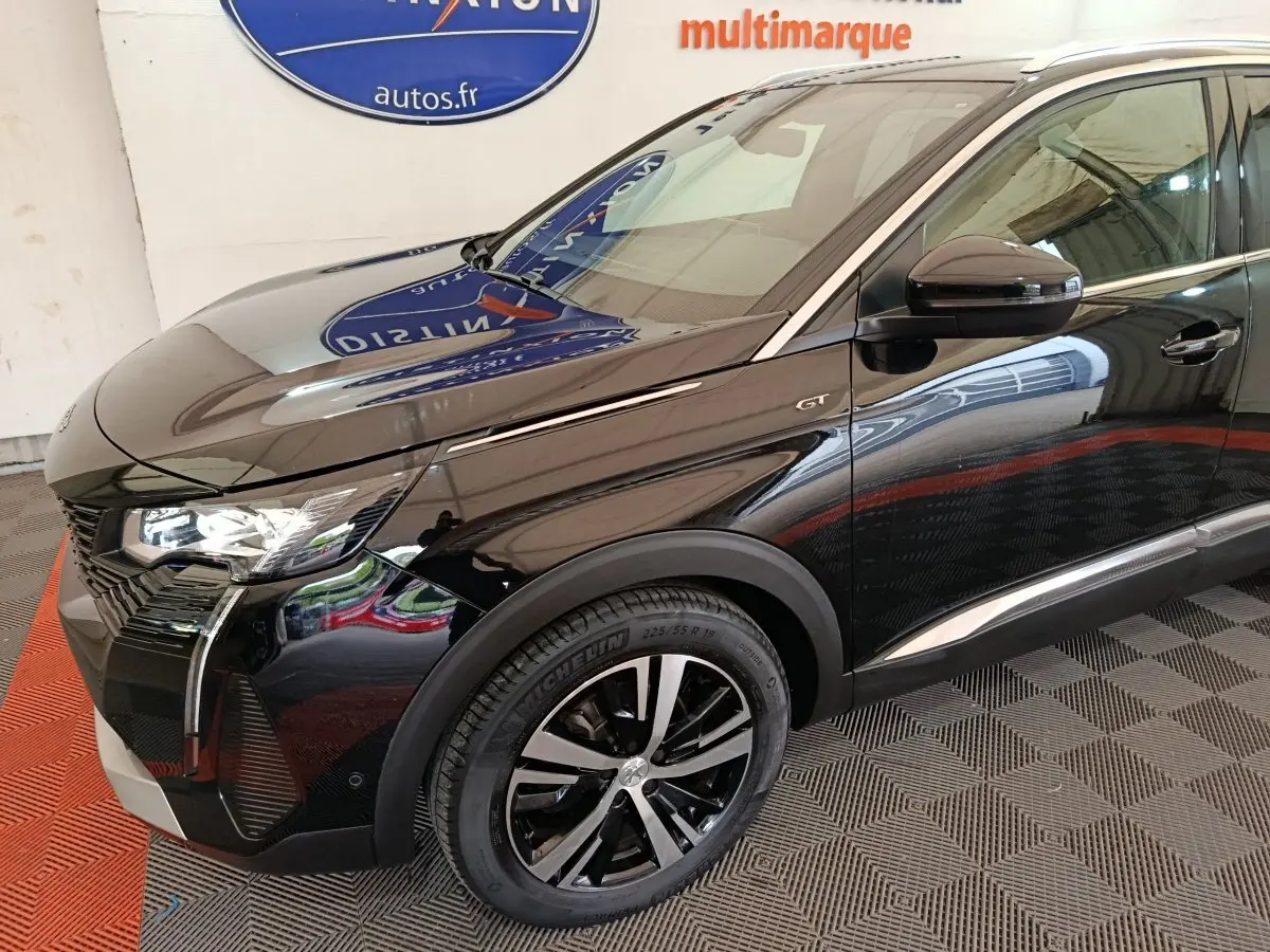 Vue 3/4 avant droit du Peugeot 3008 GT noir brillant, mettant en valeur les phares LED et la calandre distinctive.