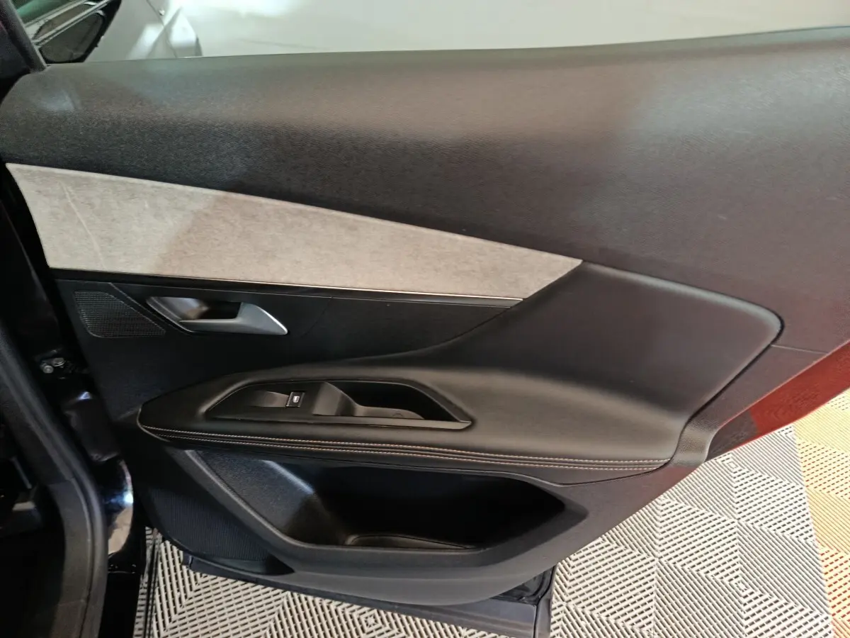 Vue intérieure de la porte côté gauche du Peugeot 3008 noir, avec garniture noire et insert gris clair.