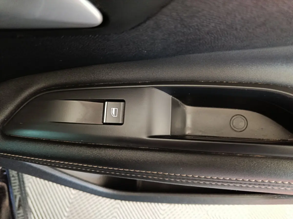 Gros plan sur le bouton de lève-vitre côté gauche noir avec surpiqûres marron du PEUGEOT 3008 PureTech 130 GT 2022.